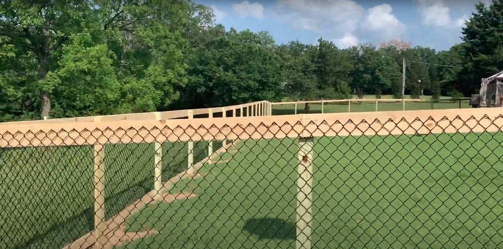 Black chain link fence with wooden posts