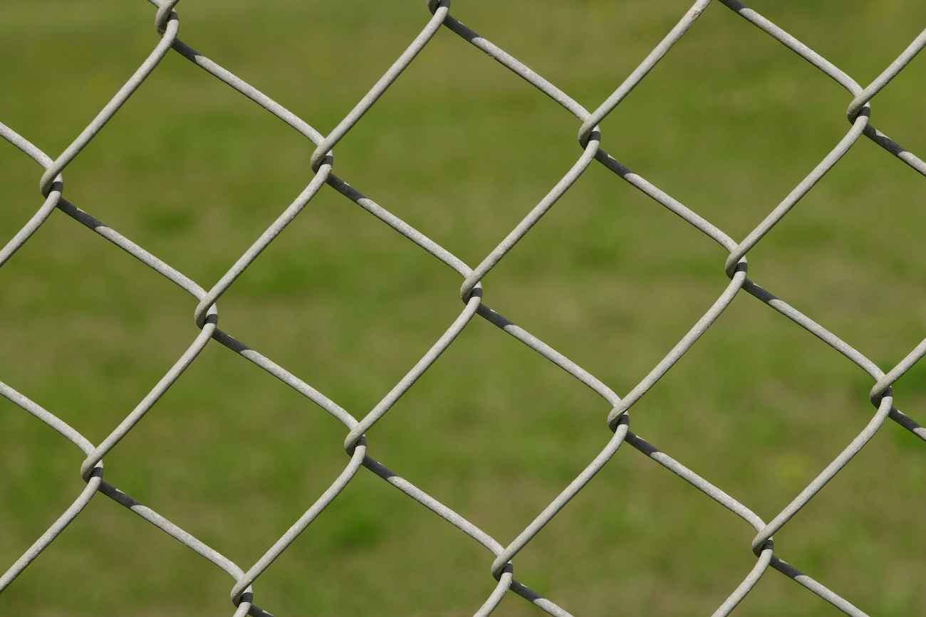 Gray chain link fence with grass in background